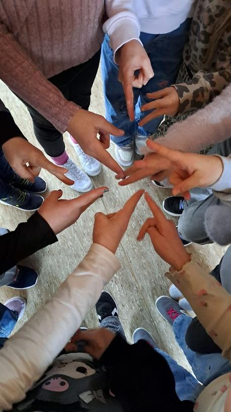 Kinder bilden mit ausgestreckten Zeigefingern einen Kreis der Gemeinschaft