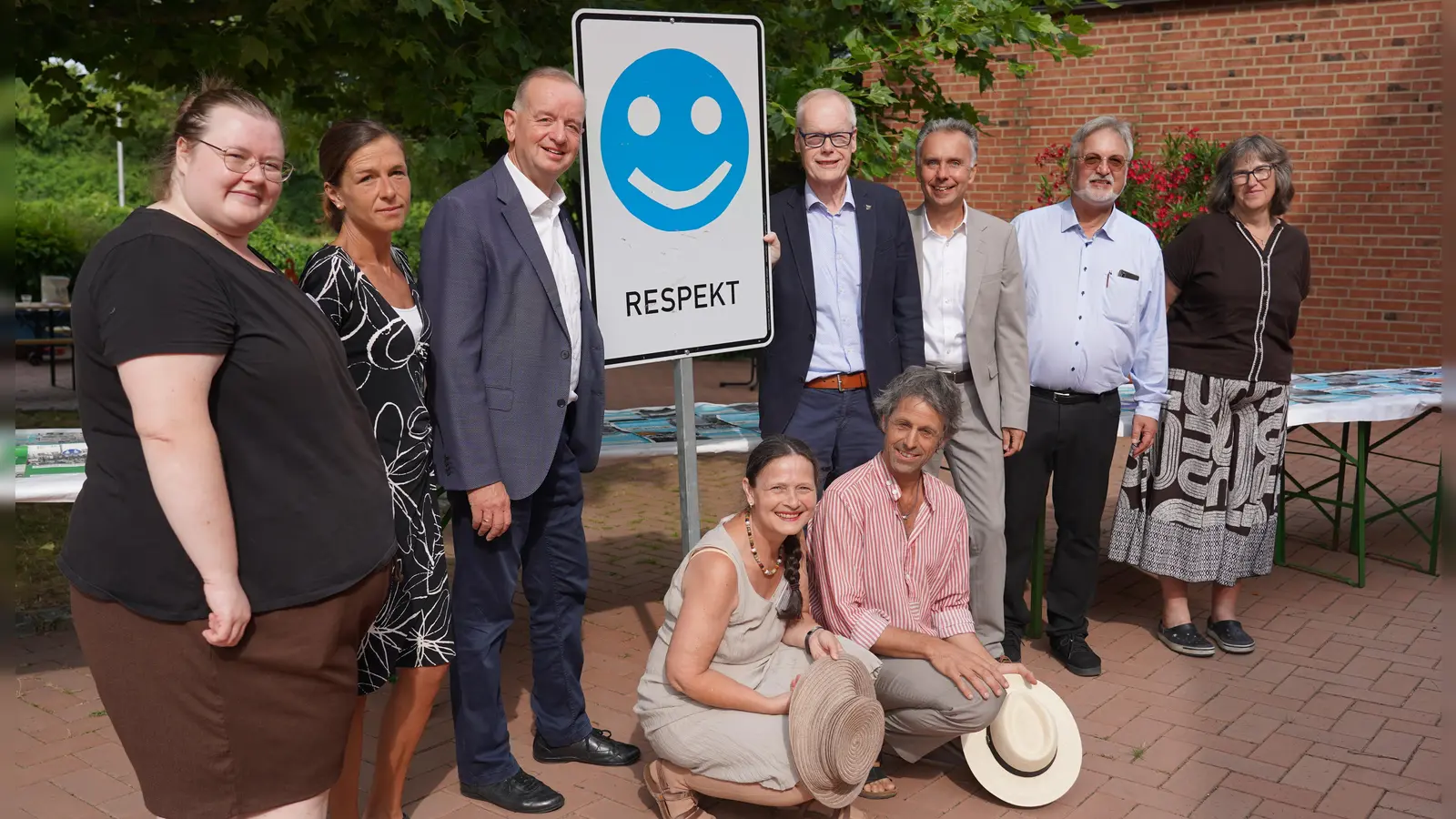 Gruppenfoto der Abschlussveranstaltung der Wanderausstellung Verkehrsschilder der Gerechtigkeit mit einem Schild „Respekt“